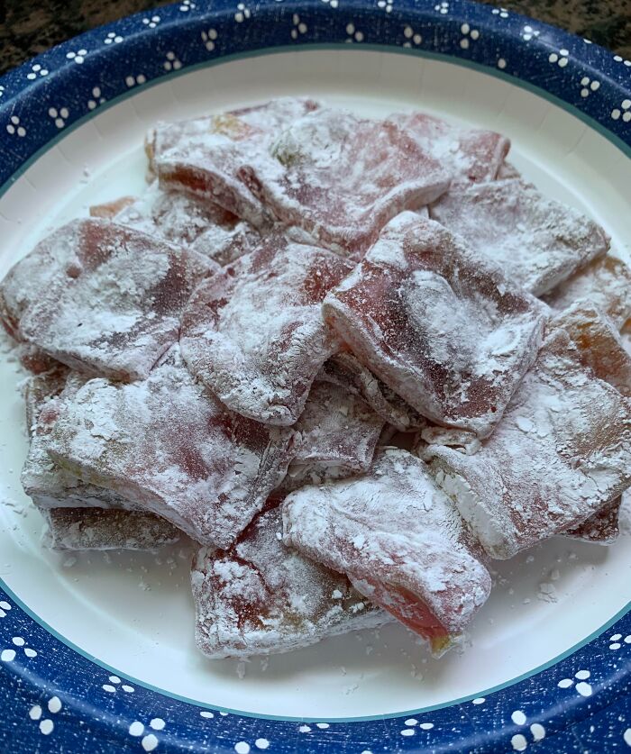 Powdered raw meat on a paper plate, part of infuriating boyfriends' cooking attempts.