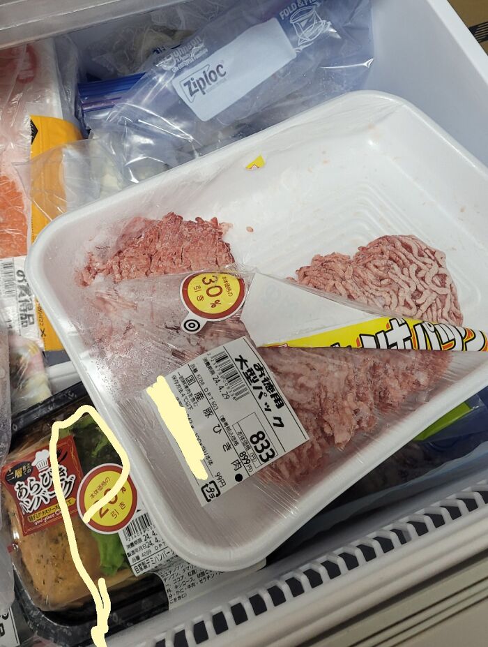 Ground meat package opened awkwardly in freezer, showing a humorous fail by boyfriends or husbands in food storage.