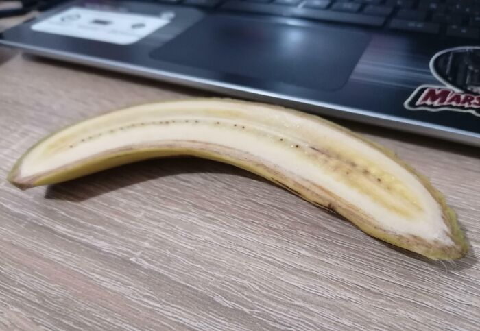 A peeled banana on a desk in front of a laptop, related to infuriating boyfriends or husbands.