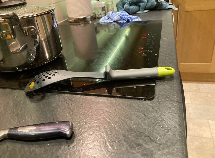 A utensil left obstructively on a stovetop, representing frustrating habits by boyfriends and husbands in the kitchen.