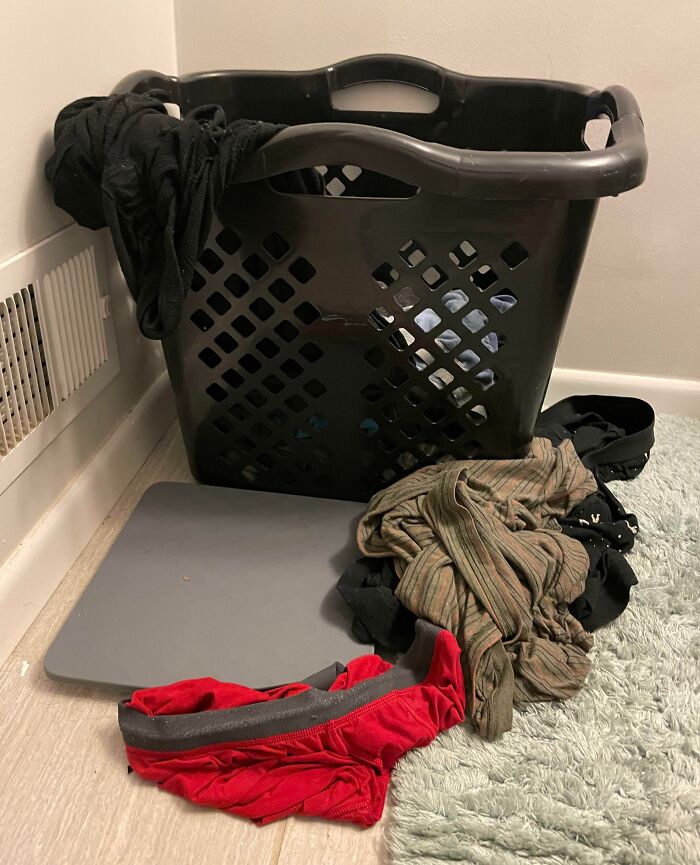 Laundry basket with clothes scattered around, capturing typical boyfriends' or husbands' infuriating habits.