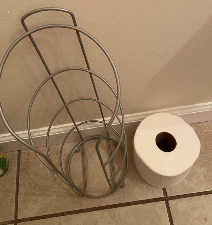 Empty toilet paper holder next to a roll on the floor, highlighting typical boyfriend or husband frustrations.