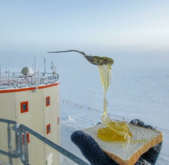 Frozen honey on bread in a snowy, winter scene beside an ice-covered building.