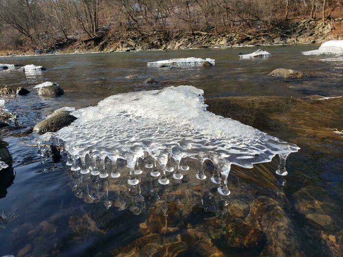 Frozen riverbank with unique ice formations during winter.