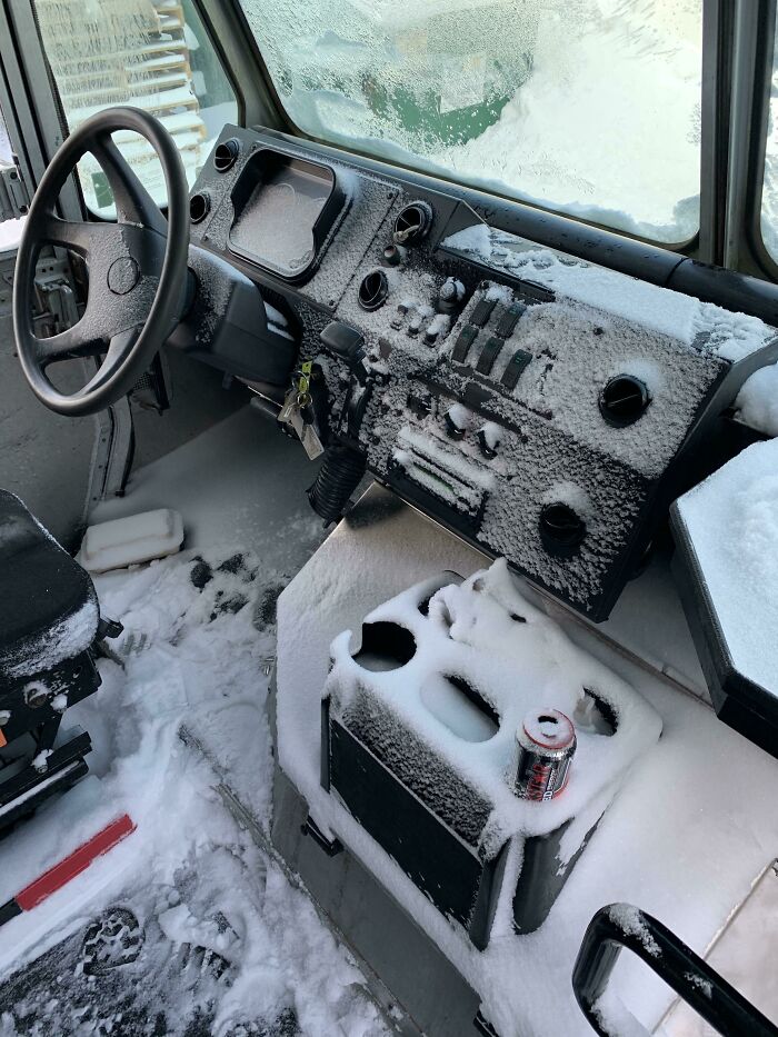 Snow-covered vehicle interior showcasing extreme ice-cold winter conditions with frosted dashboard and seats.