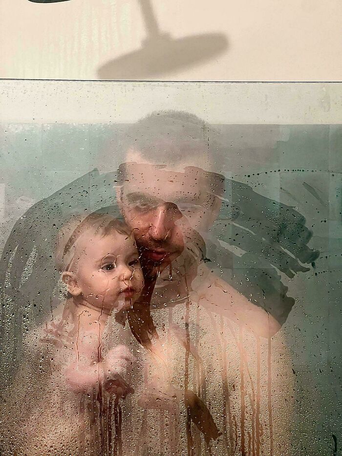 Father and child behind a steamy glass pane, resembling a Renaissance painting.