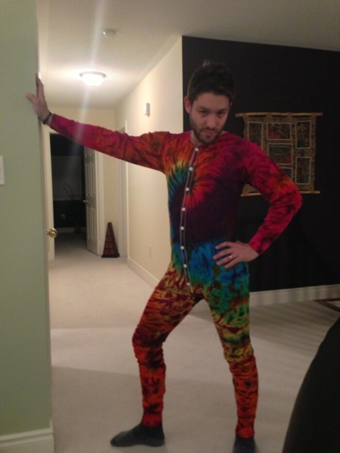 Man posing in a colorful tie-dye onesie, embodying hilarious in-laws humor.