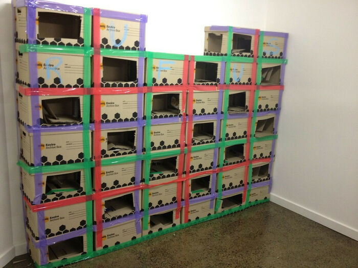 Stack of colorful moving boxes in an unusual arrangement, illustrating a hilarious in-laws' storage solution.