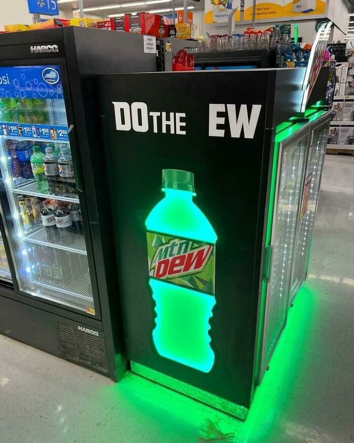 Funny ad fail with a vending machine sign reading "Do the Dew" but missing letters, showing "Do the Ew" instead.