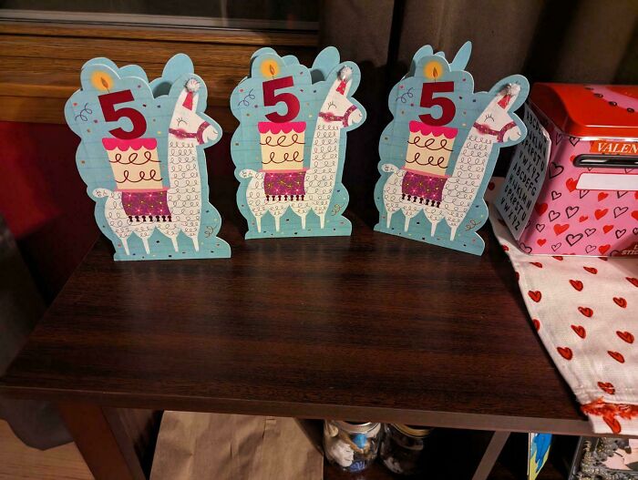 Llama-themed birthday cards featuring the number 5 on a wooden shelf, related to hilarious in-laws.