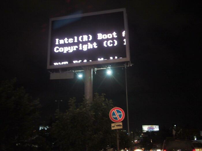 Large roadside billboard displaying a boot error message at night, illustrating funny ad fails.