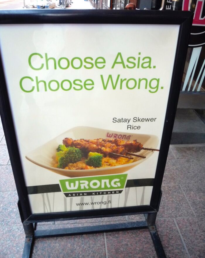 Signboard displaying satay skewer ad with text "Choose Asia. Choose Wrong," highlighting funny ad fail.