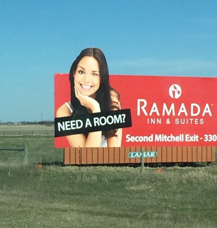 Billboard with "Need a Room?" text over a smiling woman, promoting Ramada Inn. Funny ad fail on display.