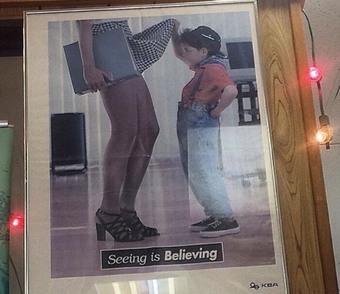 A funny ad fail showing a woman holding her skirt, revealing a surprised little boy with the text "Seeing is Believing."