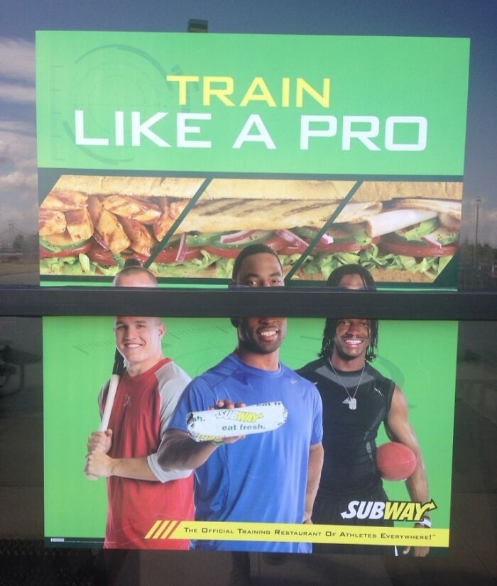 Funny ad fail with partially obscured Subway poster featuring athletes holding sandwiches.