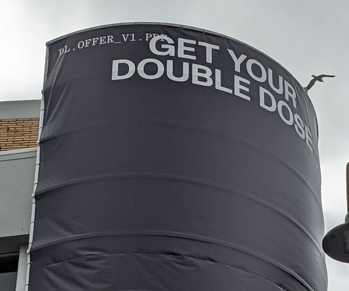 Billboard with "Get Your Double Dose" and placeholder text on top, showcasing a funny ad fail.