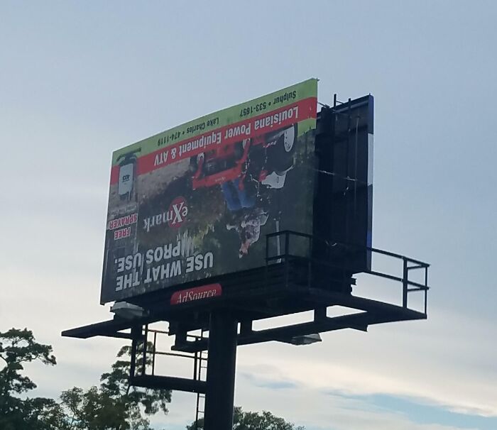 Upside-down billboard with a lawn equipment ad, showcasing funny ad fails.