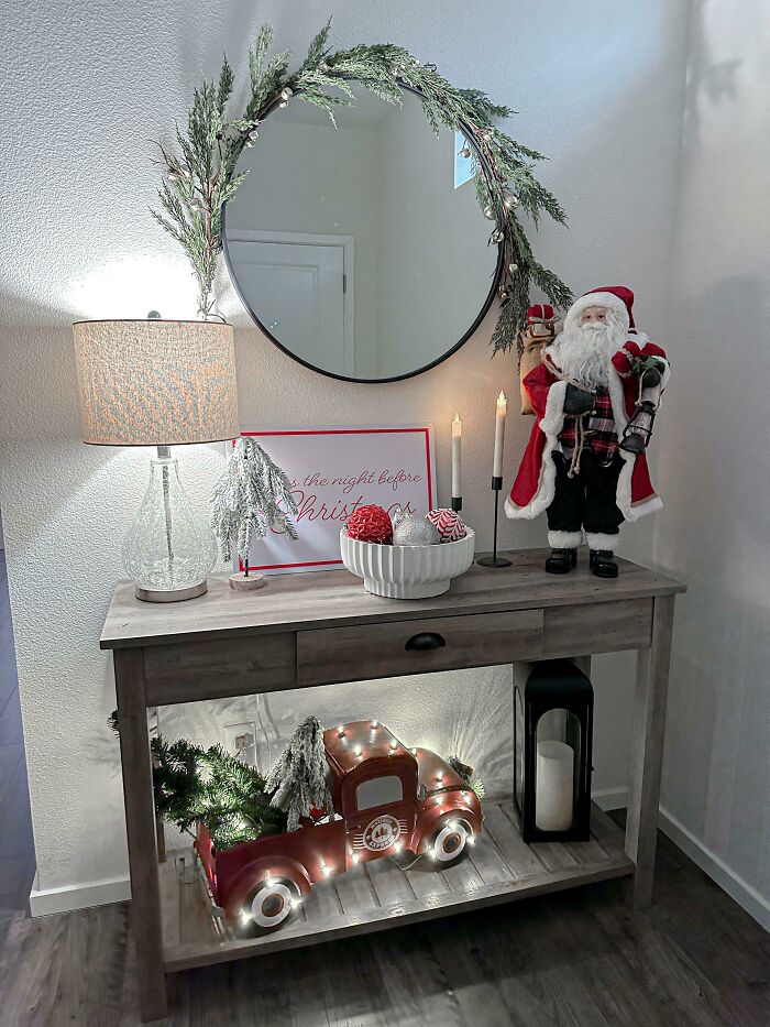 Festive Christmas decorating ideas with Santa figurine, candles, and vintage truck adorned with lights and greenery.