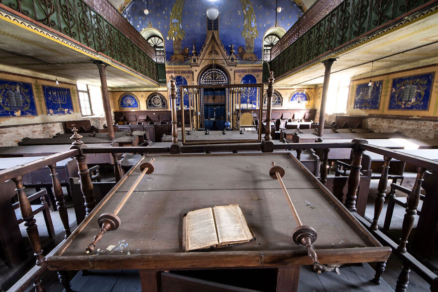 Abandoned sacred place in Europe, featuring an ornate interior with a vintage open book on a wooden table.