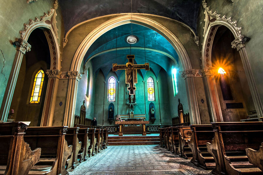 Beautiful abandoned sacred church interior in Europe with arched ceilings and stained glass windows.