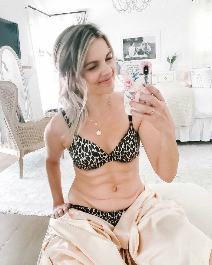 Woman taking a mirror selfie in leopard print bikini, showcasing everyday real-life style.