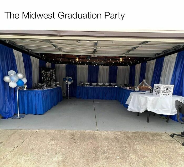 Midwest graduation party setup in a garage with blue and white decorations and tables with food.