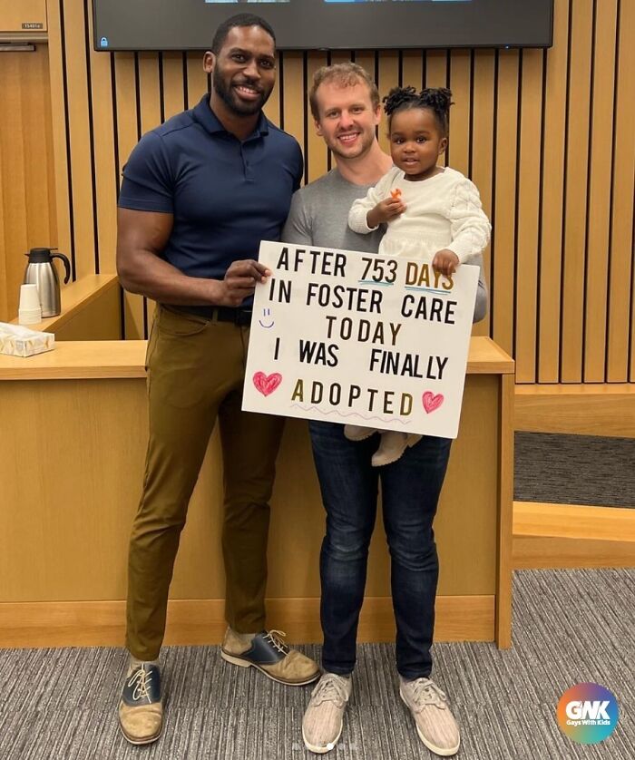 A joyful family celebrating adoption with a sign marking 753 days in foster care.