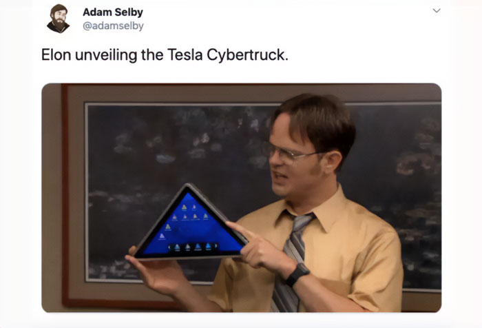 An E meme with a man humorously presenting a triangular object as Tesla Cybertruck, capturing the funny side of electric future.