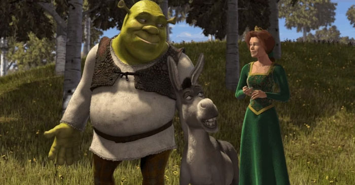 A famous trio from Shrek, featuring Shrek, Donkey, and Princess Fiona standing together in a grassy woodland area.