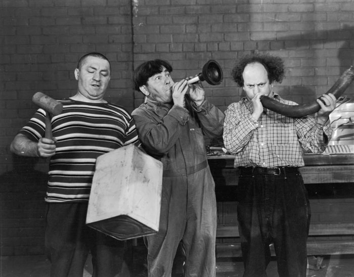 A famous trio from The Three Stooges, featuring Curly, Moe, and Larry performing a comedic scene with unconventional musical instruments.