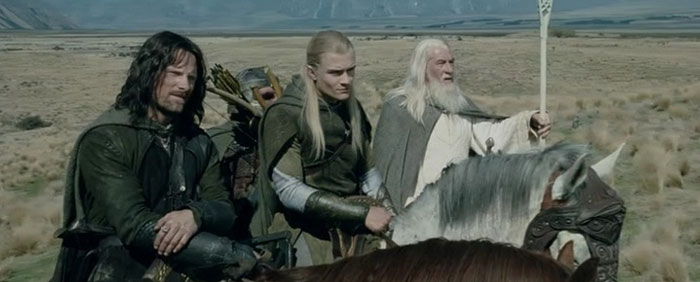 A famous trio from The Lord of the Rings, featuring Aragorn, Legolas, and Gimli riding together on horseback across an open landscape.