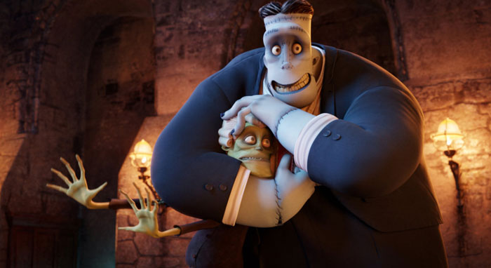 A fat cartoon character, Frankenstein's monster, wearing a suit, smiles while playfully holding a smaller, scared character in a headlock inside a dimly lit stone castle.