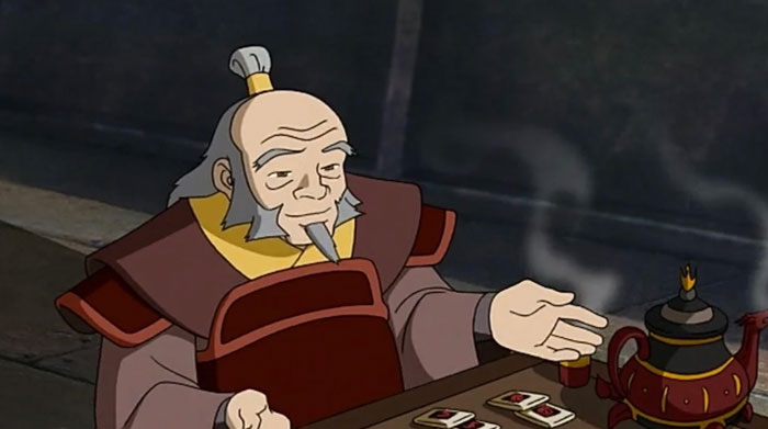 A fat cartoon character, Uncle Iroh, with a gentle expression, sits at a table with a teapot and cups, gesturing while enjoying a game indoors.