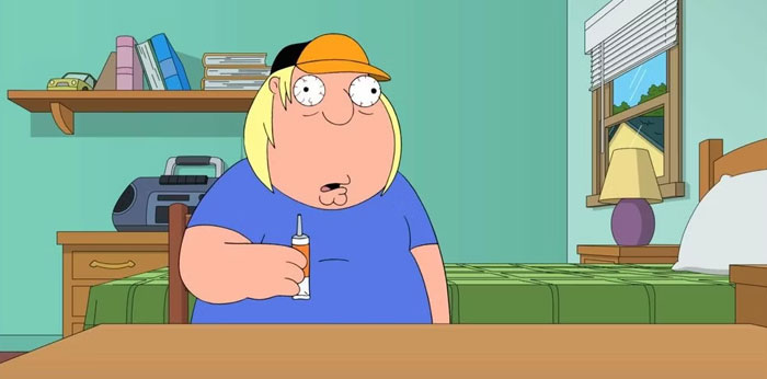 A fat cartoon character, Chris Griffin, wearing a blue shirt and a cap, looks surprised while holding a tube in a bedroom with green walls.