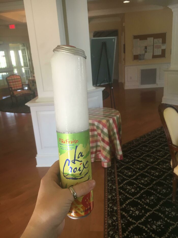 Frozen LaCroix can with ice overflowing, illustrating an ice-cold winter theme indoors.