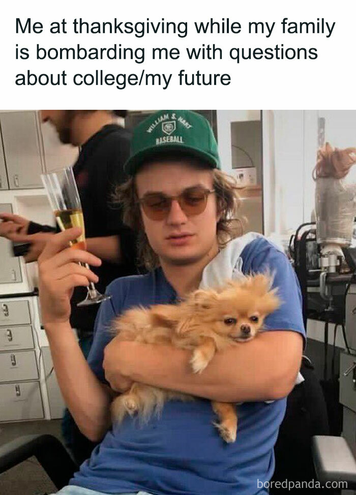 Person in a green cap and sunglasses holding a small dog and a drink, embodying a cringe-worthy November meme.