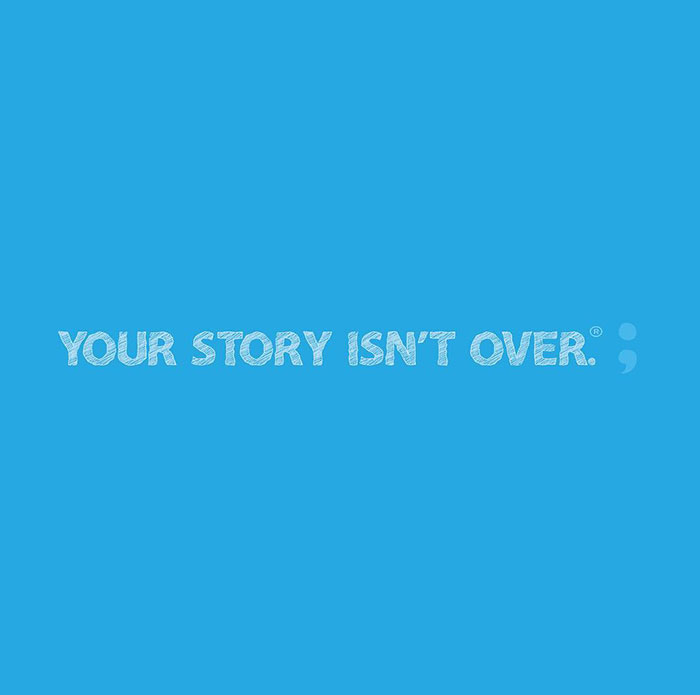 A blue background with the phrase "YOUR STORY ISN'T OVER" followed by a semicolon, symbolizing hope and resilience in Project Semicolon’s message.