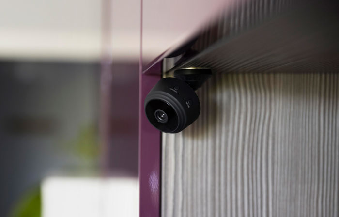 Discreet bed camera for recording mounted in a room corner.