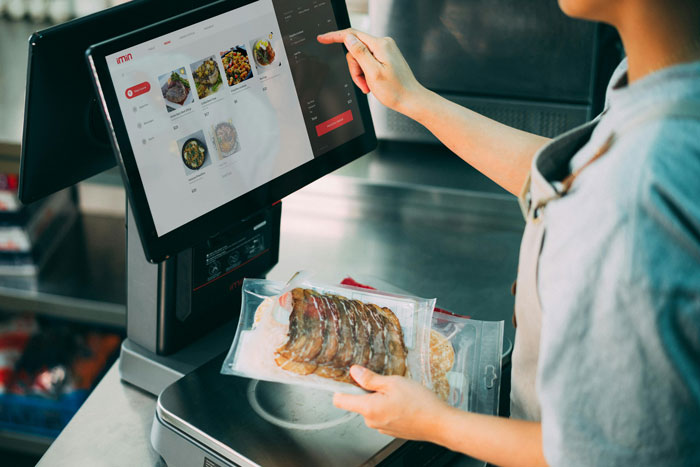 Person using a touchscreen to add extra fee to a sibling's meal bill, highlighting privileged family dynamics.