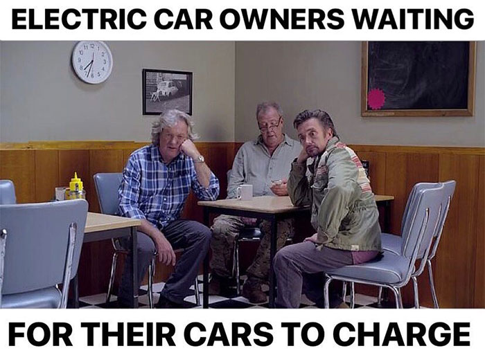 A car meme showing three men sitting bored in a diner, captioned "Electric car owners waiting for their cars to charge."