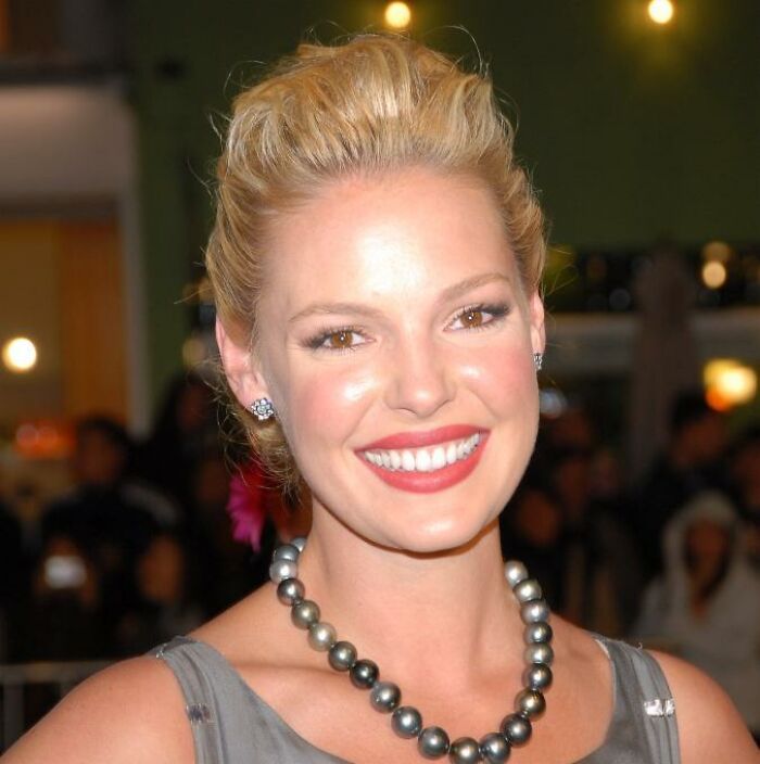 A smiling woman with blonde hair and elegant jewelry at an event, related to rudest celebrity encounters.