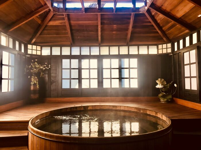 Luxurious indoor spa in a wooden home with large windows and elegant decor.