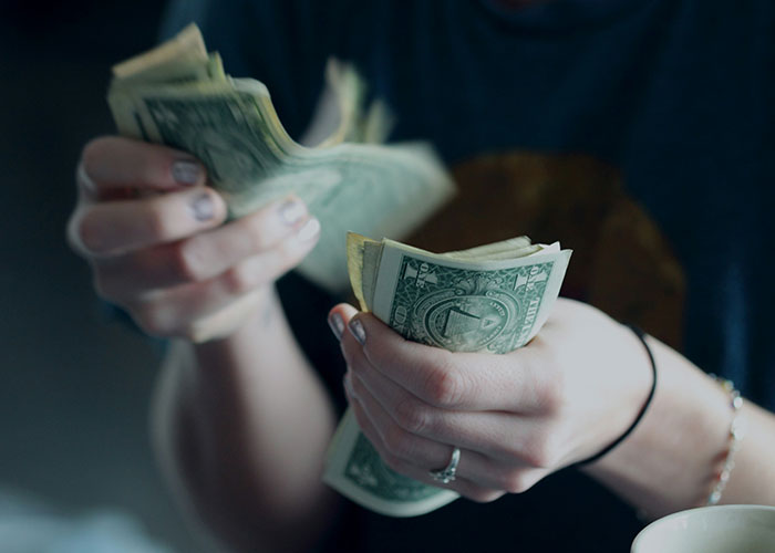 Person counting money, reflecting the concept of gut feelings being right on the money.