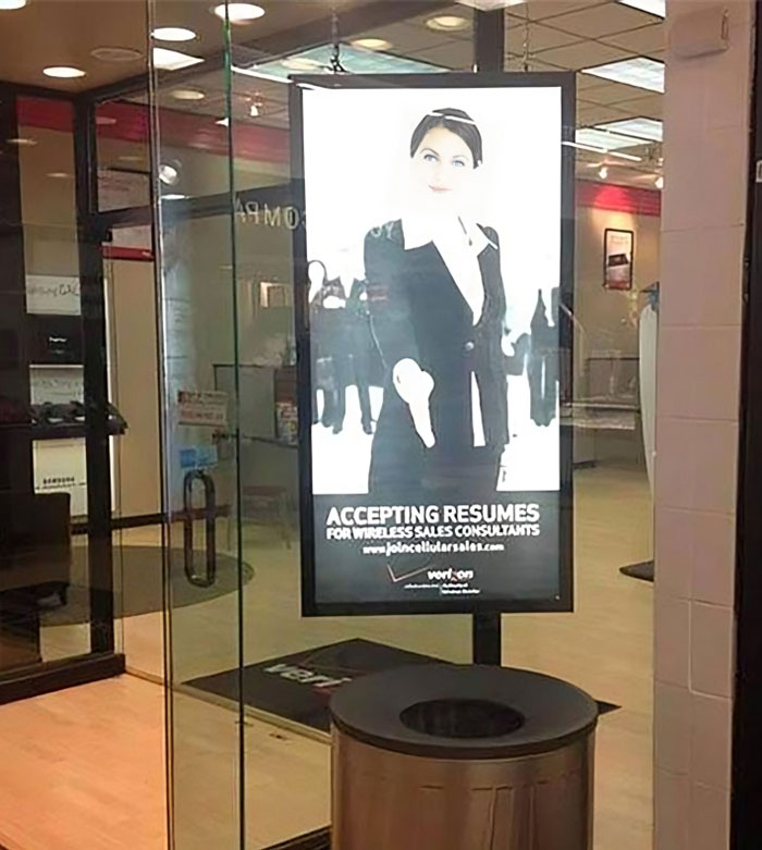 Funny ad fail with a poster suggesting resume submissions above a trash can in a store entrance.