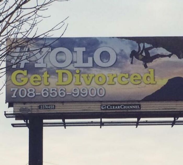 Billboard with funny ad fail reading "#YOLO Get Divorced" against a scenic backdrop.