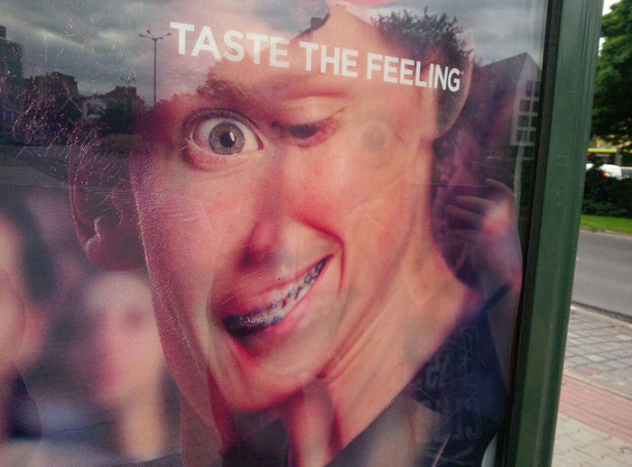 Funny ad fails with a distorted image of a person and the words "TASTE THE FEELING" on a poster.