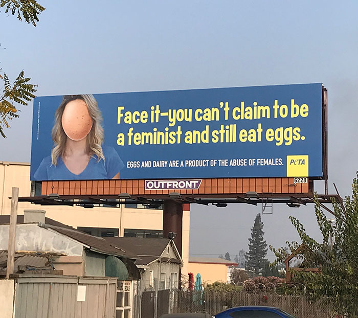 Billboard featuring a humorous ad fail with a woman's face replaced by an egg, challenging feminist values and egg consumption.