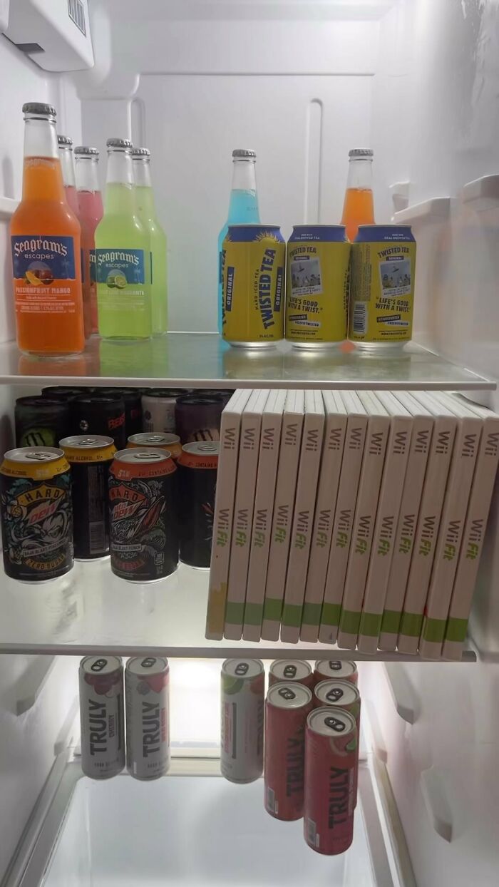 Colorful drinks and Wii Fit games stacked in a refrigerator from the Dude Fridges Instagram account.