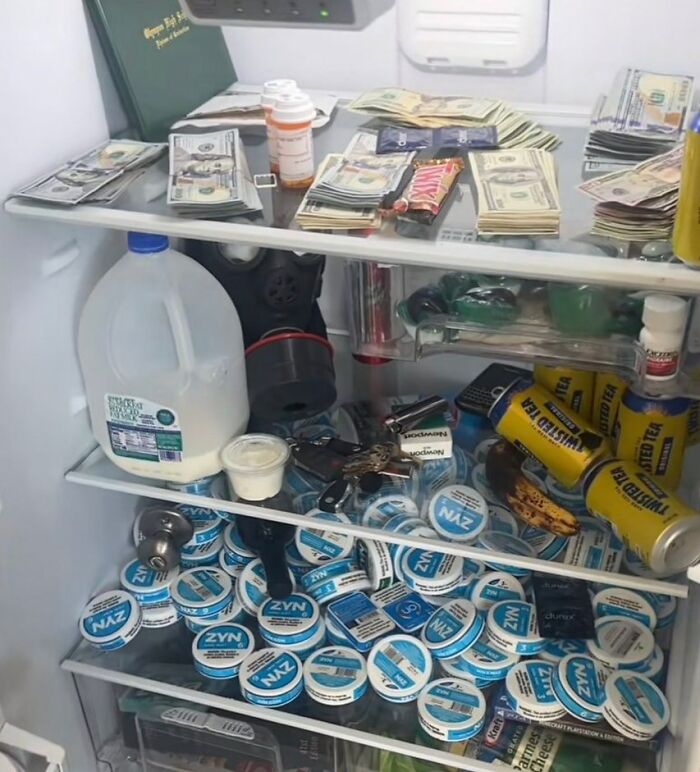 Fridge filled with cash, energy drinks, and Zyn containers, showcasing the chaotic nature of 'Dude Fridges.'