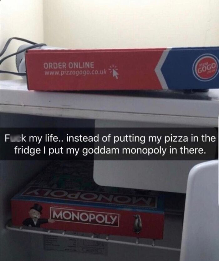 Monopoly box mistakenly stored inside a fridge above a pizza box.